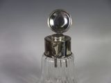 a small glass bottle with a silver top on a table