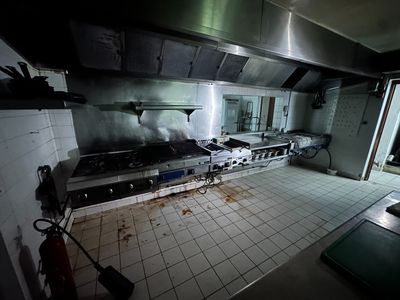une photo d'une cuisine sale avec de nombreuses traces de brûlé sur le sol