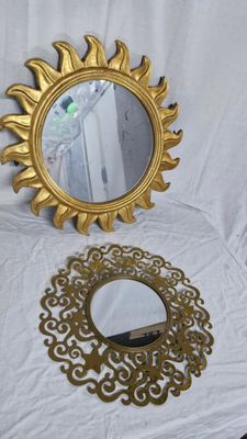 un miroir et un miroir à cadre doré posés sur une table blanche