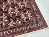 an oriental rug with a red and beige design on a white floor