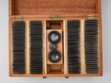 a wooden box with a bunch of hair brushes inside of it