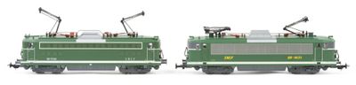 two green trains sitting side by side on a white surface