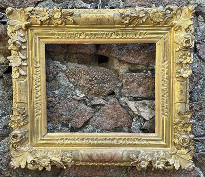 une photo représentant un cadre accroché à un mur en pierre