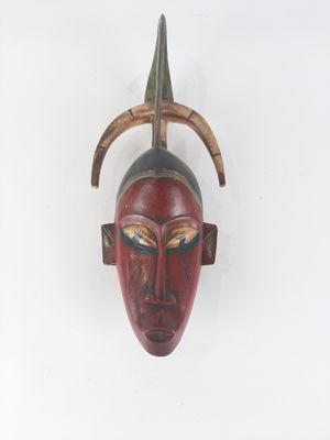 an image of a wooden mask hanging on a wall