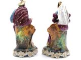 two figurines of a man and a woman sitting on top of each other