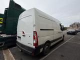a white van parked in a parking lot next to a green truck