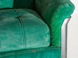 a close up of a green couch with a metal frame