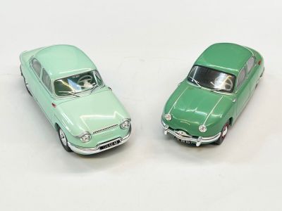 deux petites voitures posées côte à côte sur une surface blanche