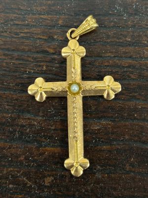 un gros plan d'une croix sur une surface en bois