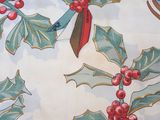 holly leaves and red berries on a white background with a red bow