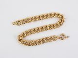 a close up of a gold chain on a white surface