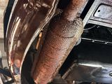 a close up of a car ' s exhaust pipe and exhaust muffler