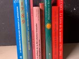 Plusieurs livres sont alignés sur une étagère devant un mur noir