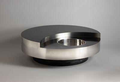 a metal bowl with a black top on a table