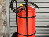 un extincteur et un diable devant la porte d'un garage