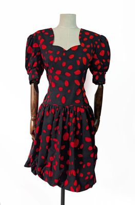 robe à pois rouges et noirs avec des manches bouffantes sur un mannequin