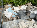 a pile of junk sitting on the ground next to a fence
