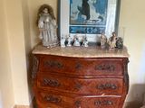 a picture of a dresser in a room with a painting on the wall