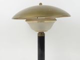a brass and black table lamp on a white background