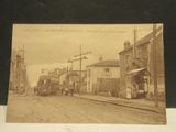 une vieille photo représentant une scène de rue avec un train qui arrive sur les rails