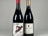two bottles of wine sitting next to each other on a table