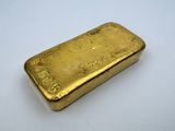 une barre d'or posée sur une surface blanche