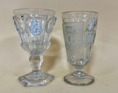 two glass goblets sitting next to each other on a table