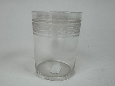 un verre transparent muni d'un couvercle en plastique, posé sur une table blanche