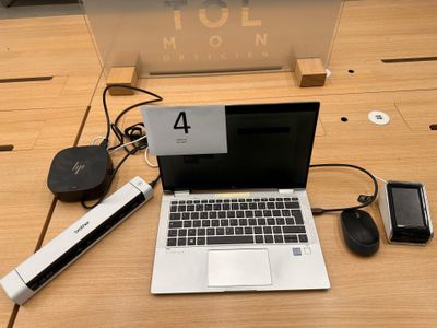 a laptop computer sitting on a desk with a lot of accessories