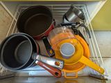 Plusieurs casseroles et poêles sont posées sur une étagère dans une cuisine