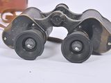 a pair of binoculars sitting on a table next to a bag