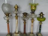 four antique lamps are lined up against a white background