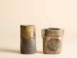deux petits vases posés l'un à côté de l'autre sur une table