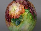 a vase with flowers painted on it sitting on a table
