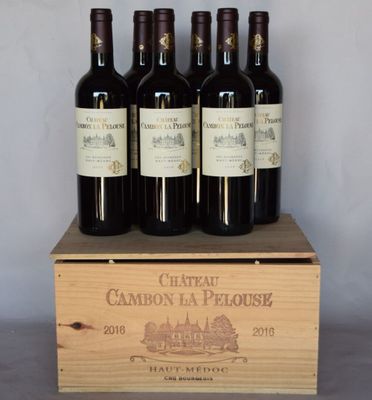 quatre bouteilles de vin se trouvent dans une caisse en bois posée sur une table