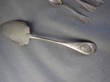 four spoons and two spoons sitting on a table