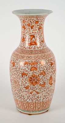 un vase orange et blanc posé sur une table blanche