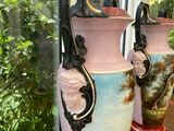 two vases that are sitting on a table in front of a window