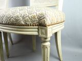 a white chair with a patterned seat and a wooden frame