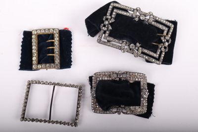 three pieces of black velvet and silver metal buckles on a white surface