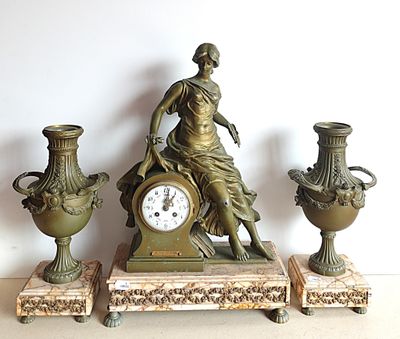 une statue représentant une femme assise sur une table, à côté de trois vases et d'une horloge