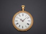 a gold pocket watch with roman numerals on the face