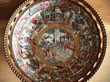 a plate with a painting on it hanging on a wall