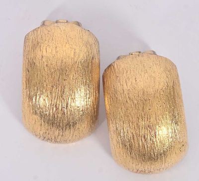 pair of gold toned metal napkin napkins on a white surface