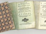 three old books sitting on top of each other on a table