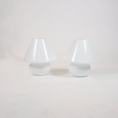 two white lamps that are sitting on a white surface
