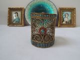 a small vase sitting on a table next to pictures