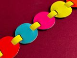 brightly colored circles are arranged in a row on a red surface