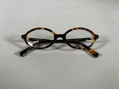 une paire de lunettes posée sur une surface blanche