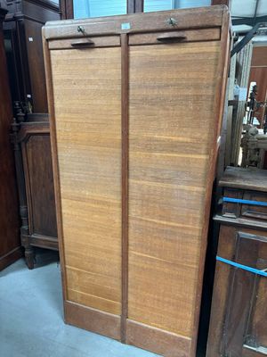 une armoire en bois dans une pièce où se trouve un miroir accroché au mur